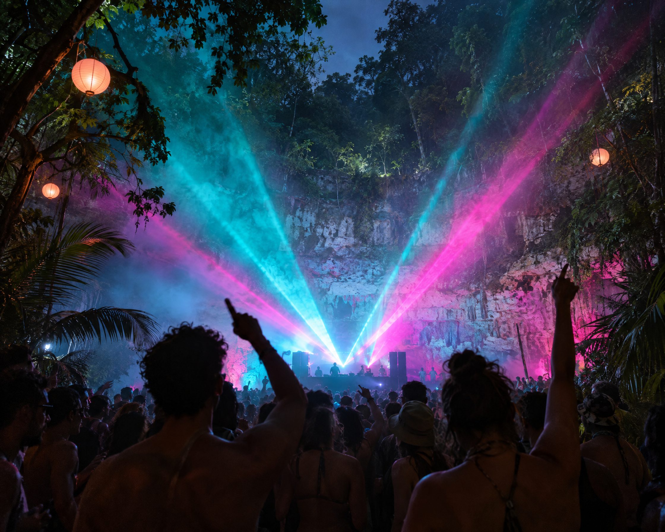 Turquoise and pink lasers over the crowd at a stage on the rim of a sinkhole